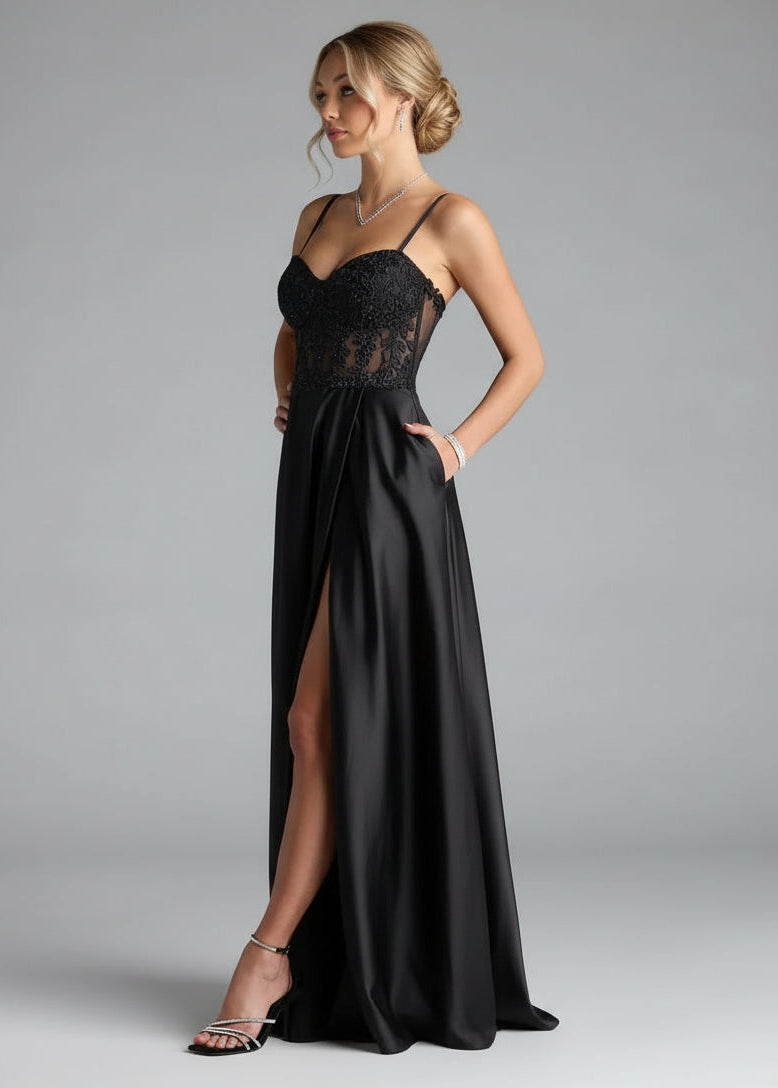 Black evening gown with lace detailing on a gray background