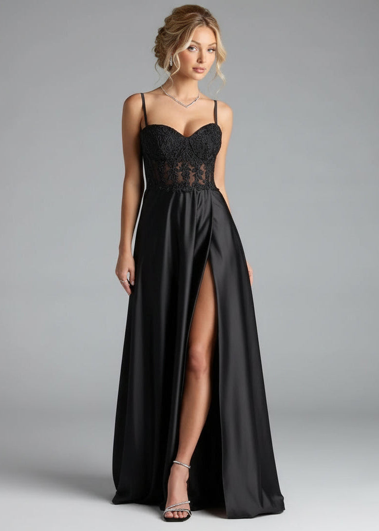 Woman wearing a black lace dress with a high slit on a gray background