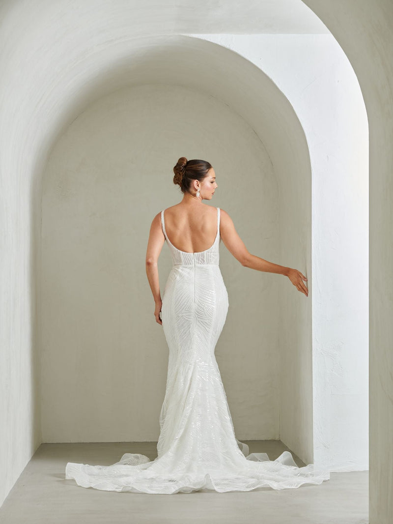 Woman in a white wedding dress standing in an archway