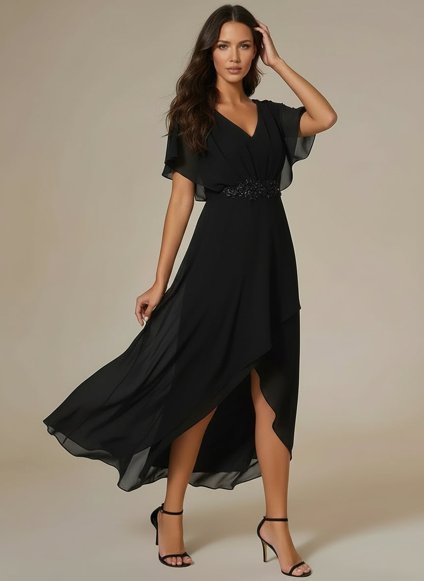 Woman wearing a black dress with a slit on a beige background