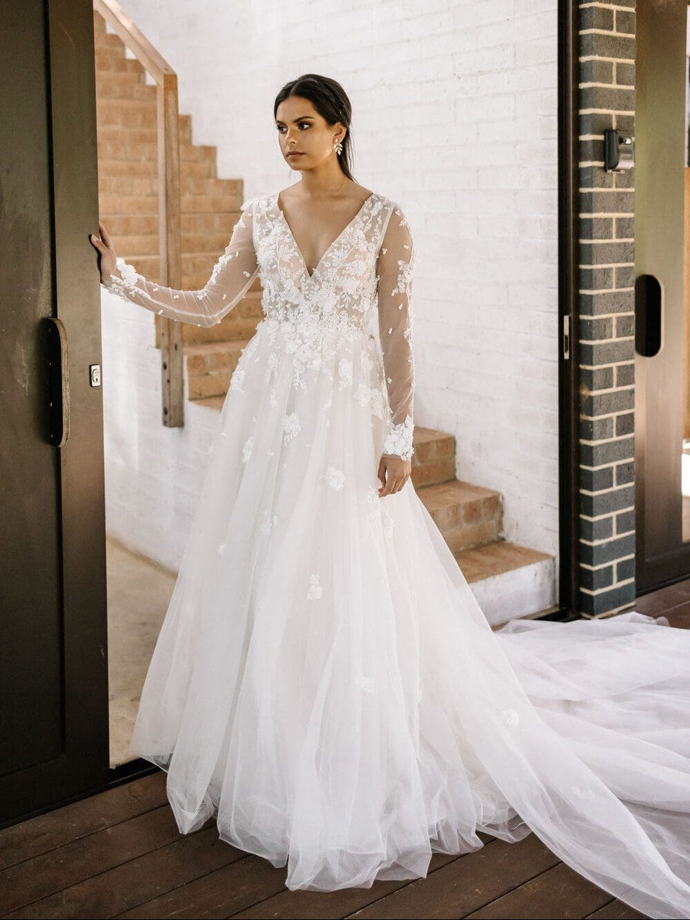 Woman in a white wedding dress standing in a doorway.