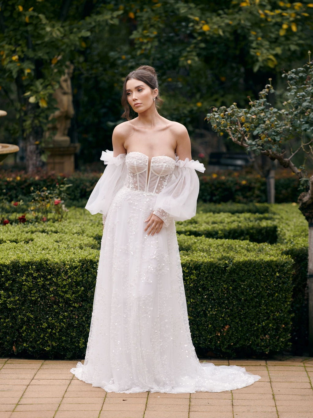 Woman in a white wedding dress standing in a garden setting