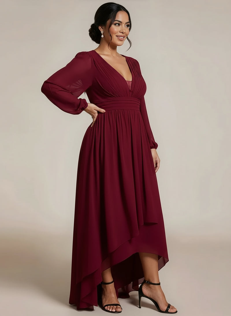 Woman wearing a burgundy dress with long sleeves on a plain background