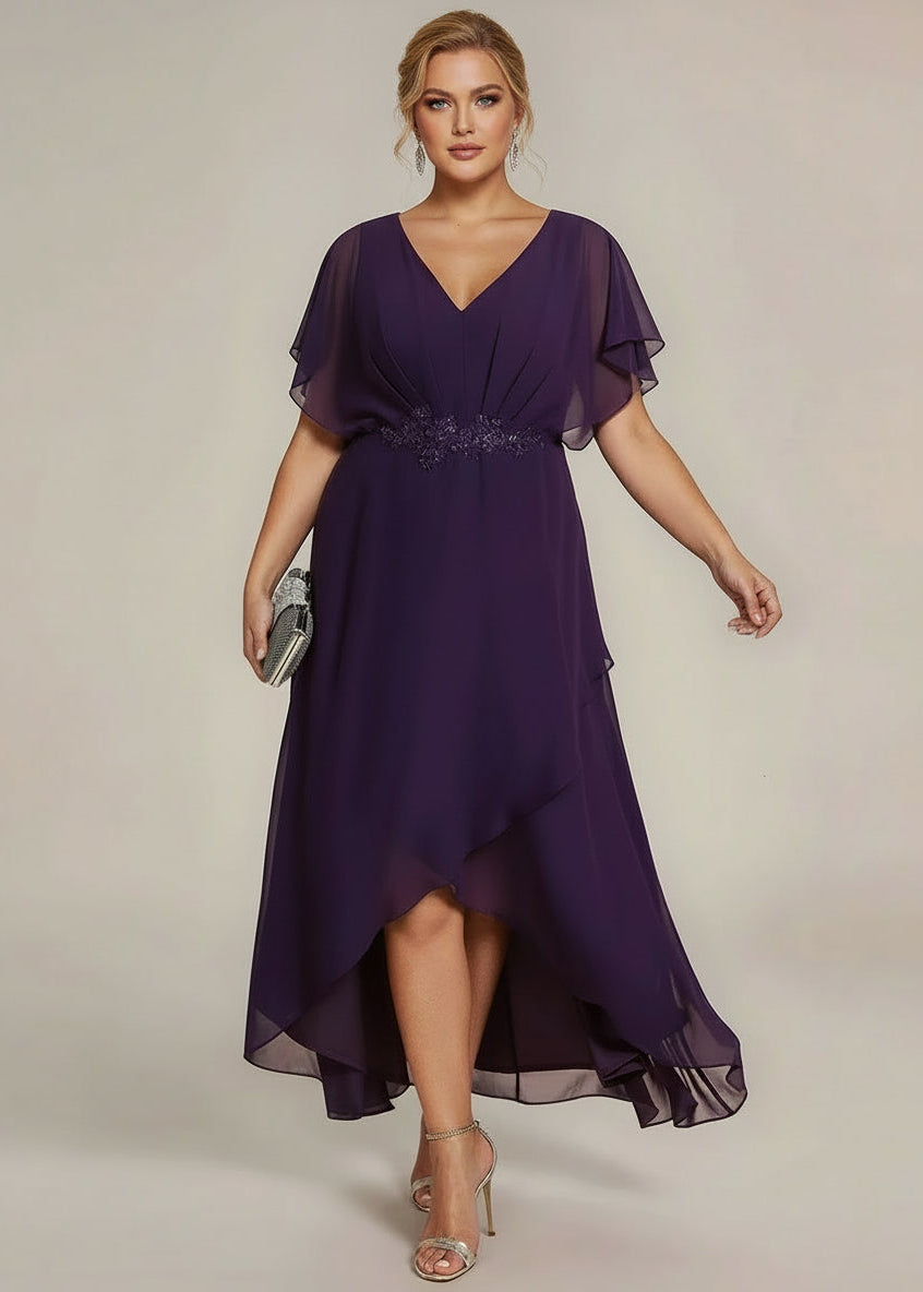 Woman wearing a purple dress with sheer sleeves against a beige background
