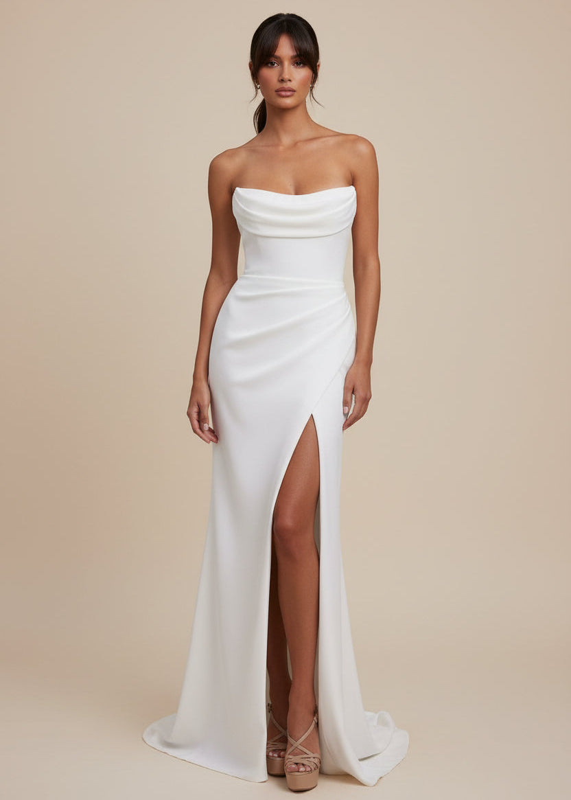 Woman in a white one-shoulder gown with a high slit 