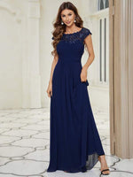 Woman posing in navy blue lace and chiffon bridesmaid gown